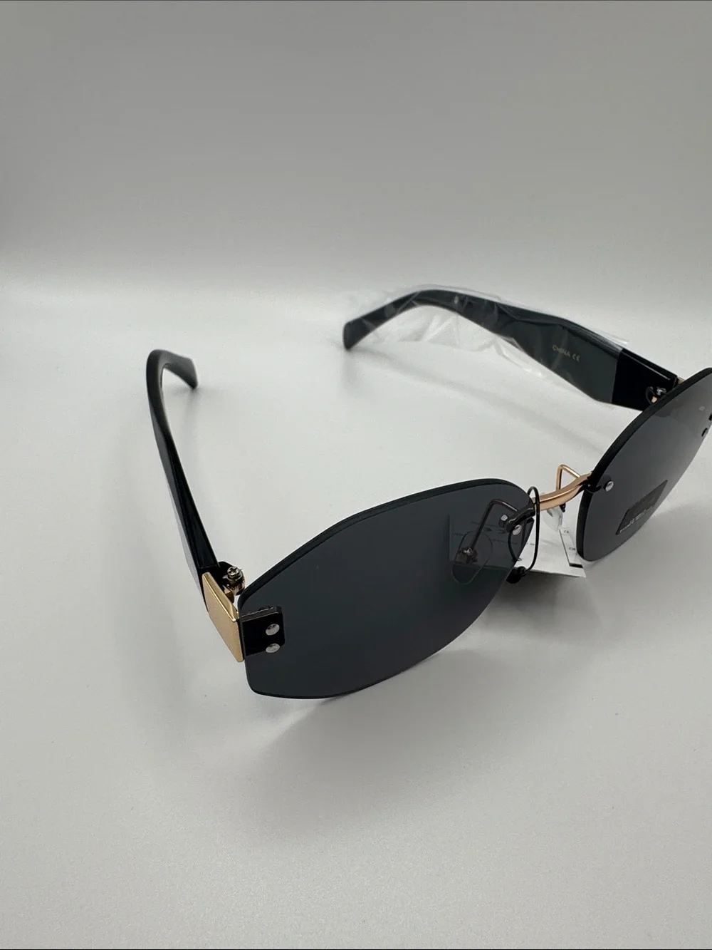 Stylish Black Rimless Women's Sunglasses with Gold Bridge